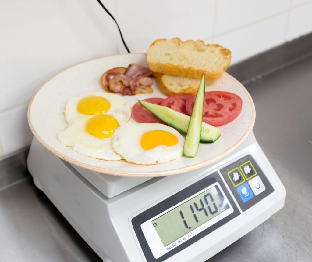Weighing menu item on a scale to determine portion weight for accurate recipe costing.